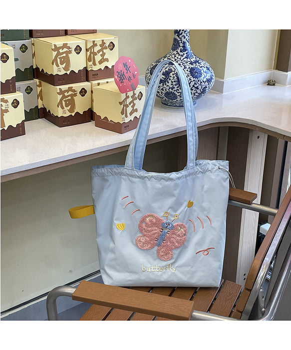 Wholesale Niche cartoon embroidered shoulder bag, simple and large capacity drawstring canvas bag, commuting tote bag for work