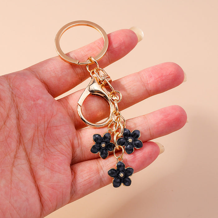Wholesale Cherry blossom metal keychains available in various colors.