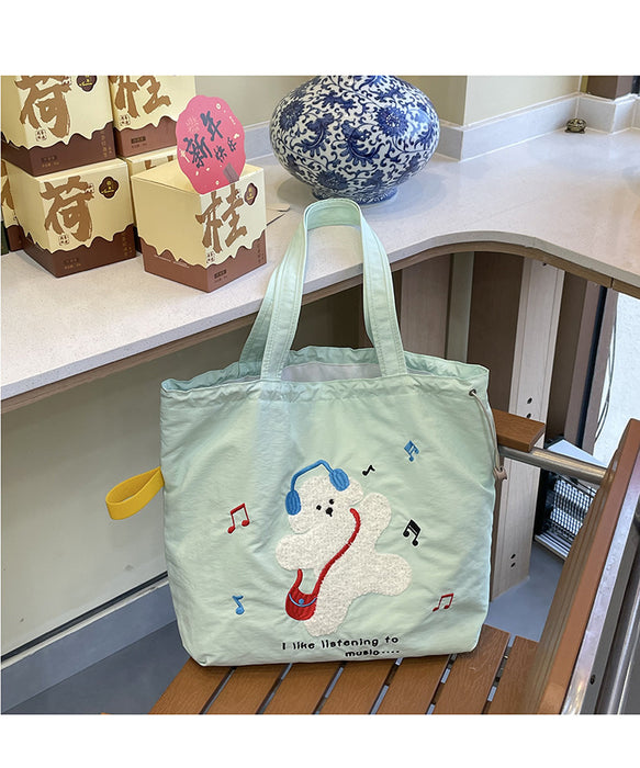 Wholesale Niche cartoon embroidered shoulder bag, simple and large capacity drawstring canvas bag, commuting tote bag for work