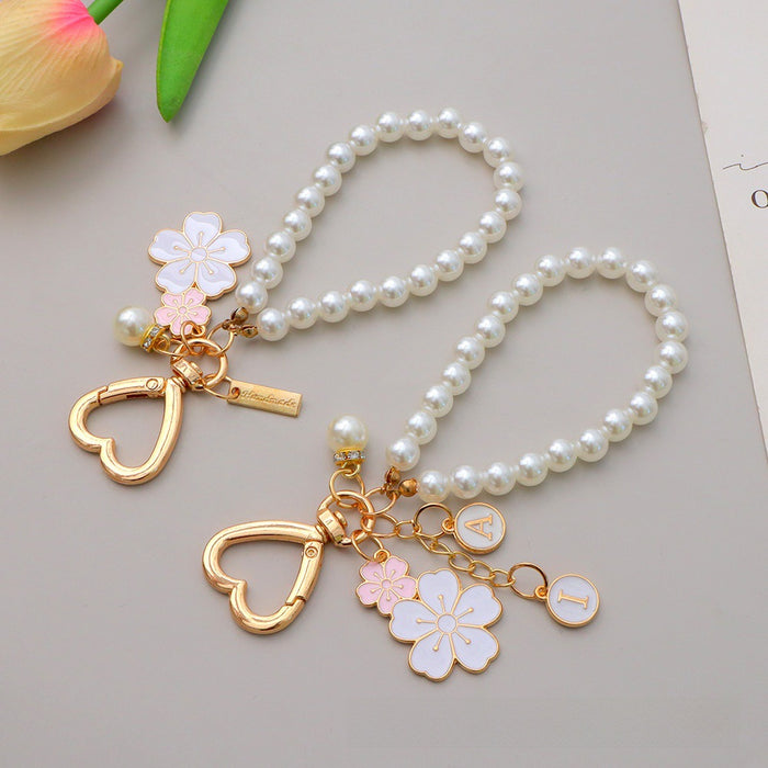 Wholesale Two tone flower alloy keychain pendant, cute letters, pearl accessories, headphone cover, bag, hanging decoration