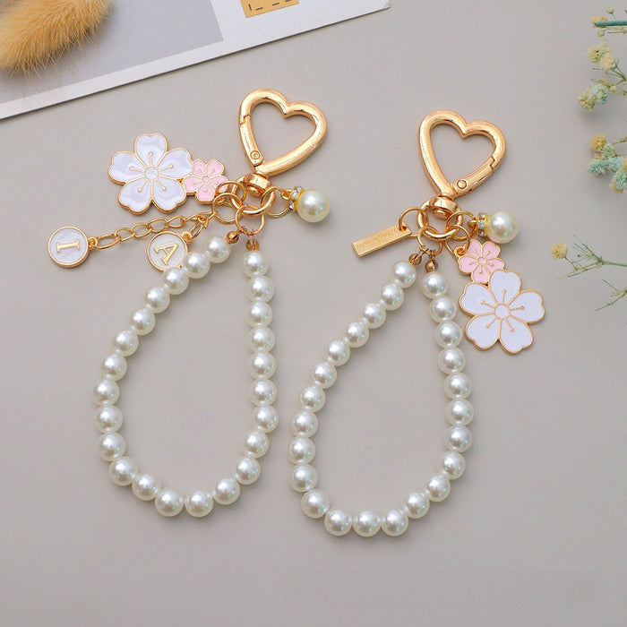 Wholesale Two tone flower alloy keychain pendant, cute letters, pearl accessories, headphone cover, bag, hanging decoration