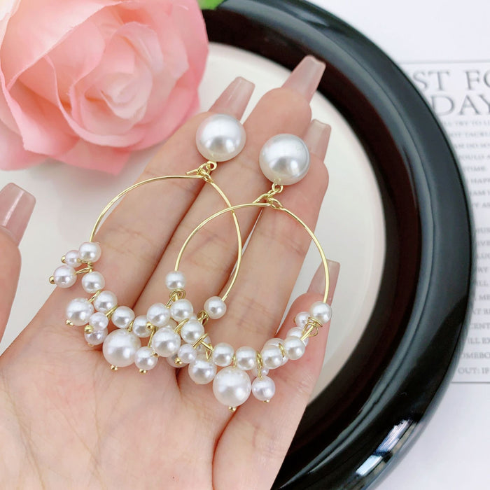 Wholesale Hollow out circle long pearl earrings with a minimalist and slimming style, featuring tassel earrings