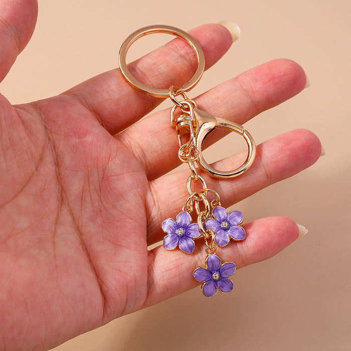Wholesale Cherry blossom metal keychains available in various colors.