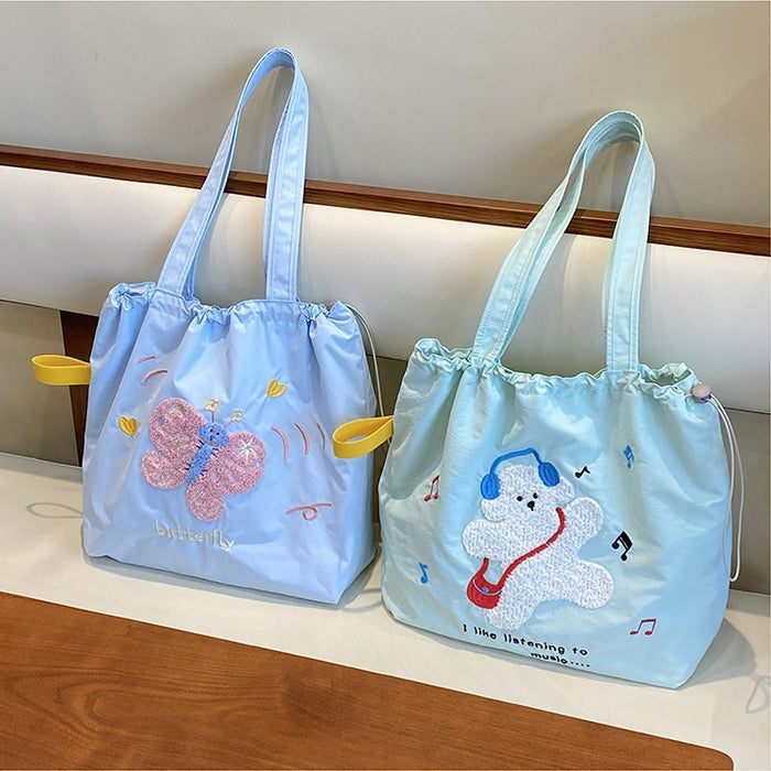 Wholesale Niche cartoon embroidered shoulder bag, simple and large capacity drawstring canvas bag, commuting tote bag for work