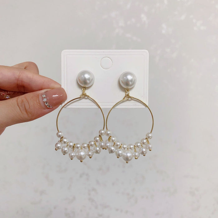 Wholesale Hollow out circle long pearl earrings with a minimalist and slimming style, featuring tassel earrings
