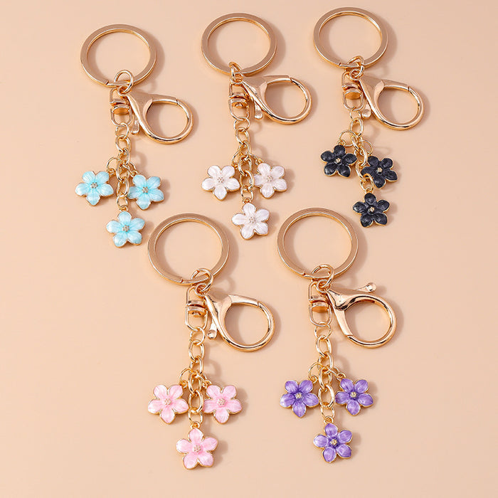 Wholesale Cherry blossom metal keychains available in various colors.