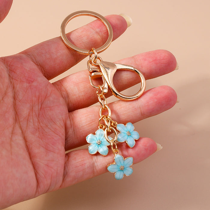 Wholesale Cherry blossom metal keychains available in various colors.