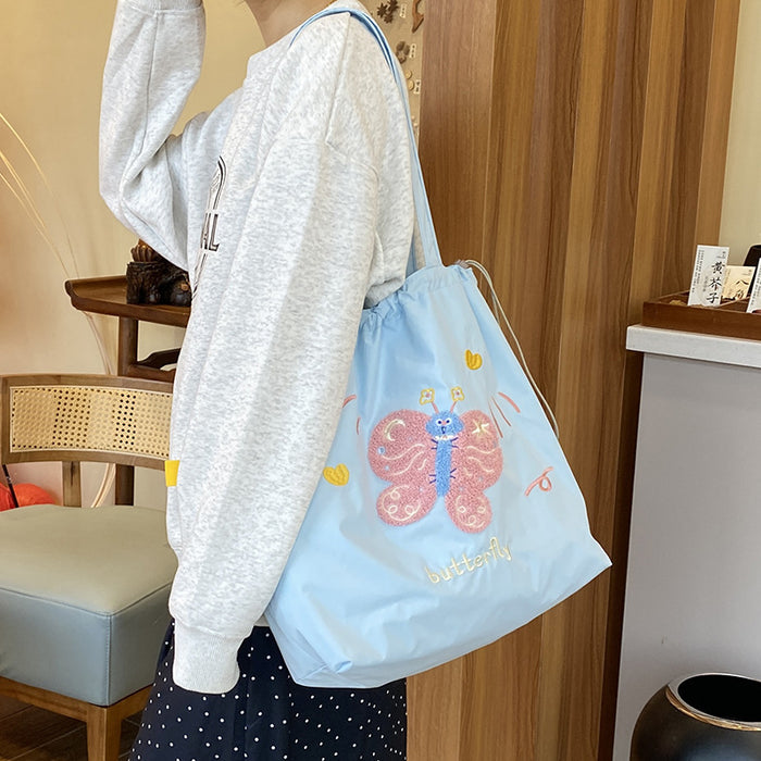Wholesale Niche cartoon embroidered shoulder bag, simple and large capacity drawstring canvas bag, commuting tote bag for work